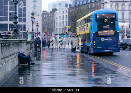 Dublin, Ireland. 3rd Dec, 2017. Homeless man begging on O`Connell bridge in Dublin on a rainy December day Stock Photo